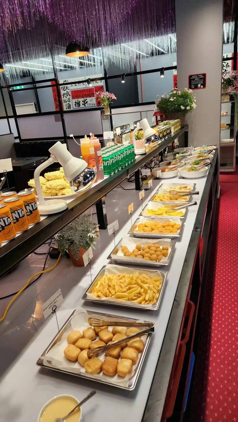 Trays of deep-fried mini buns, hot chips and golden fried pieces along the buffet counter